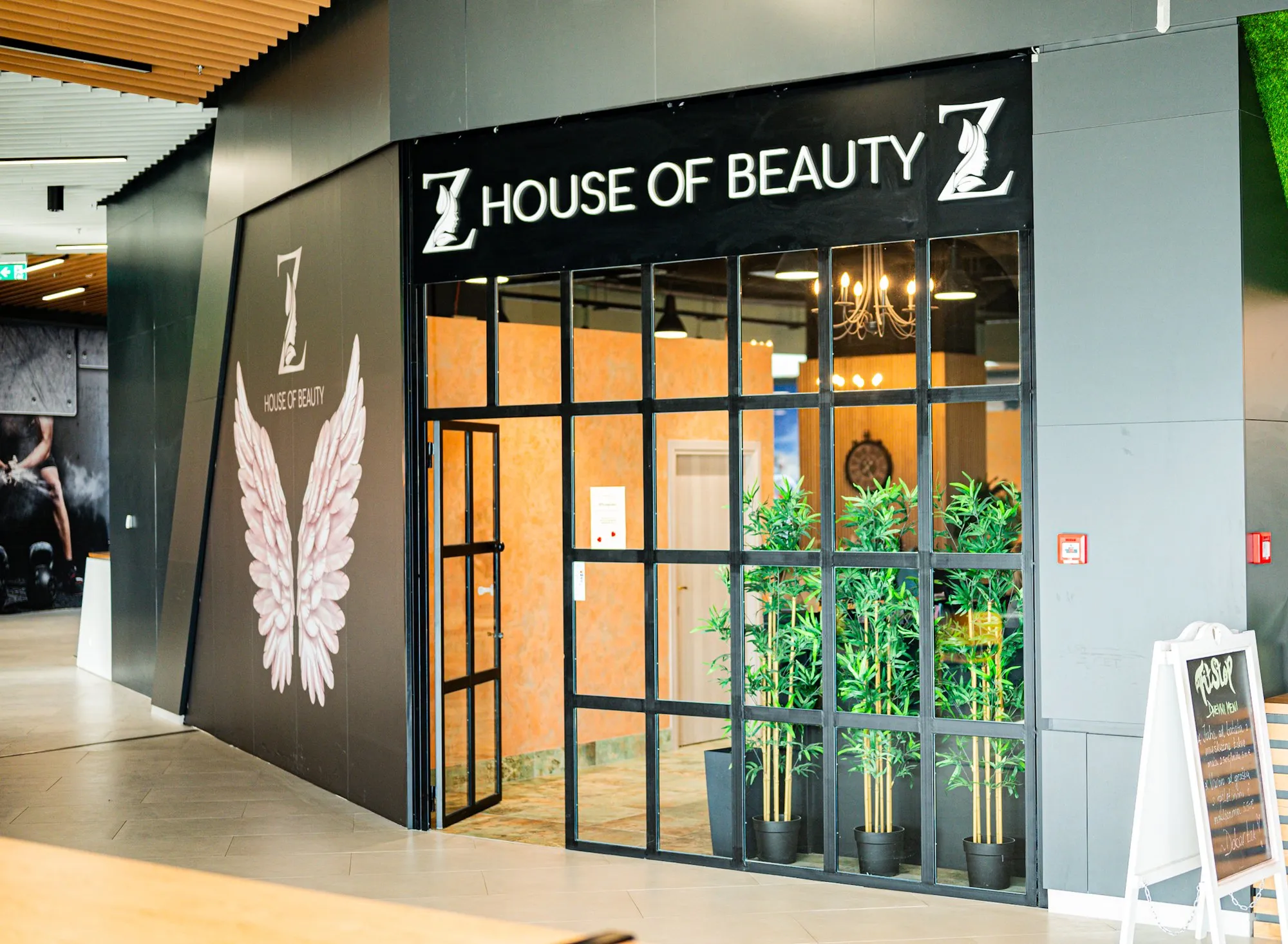 Izlog salona s natpisom House of Beauty i oslikanim krilima