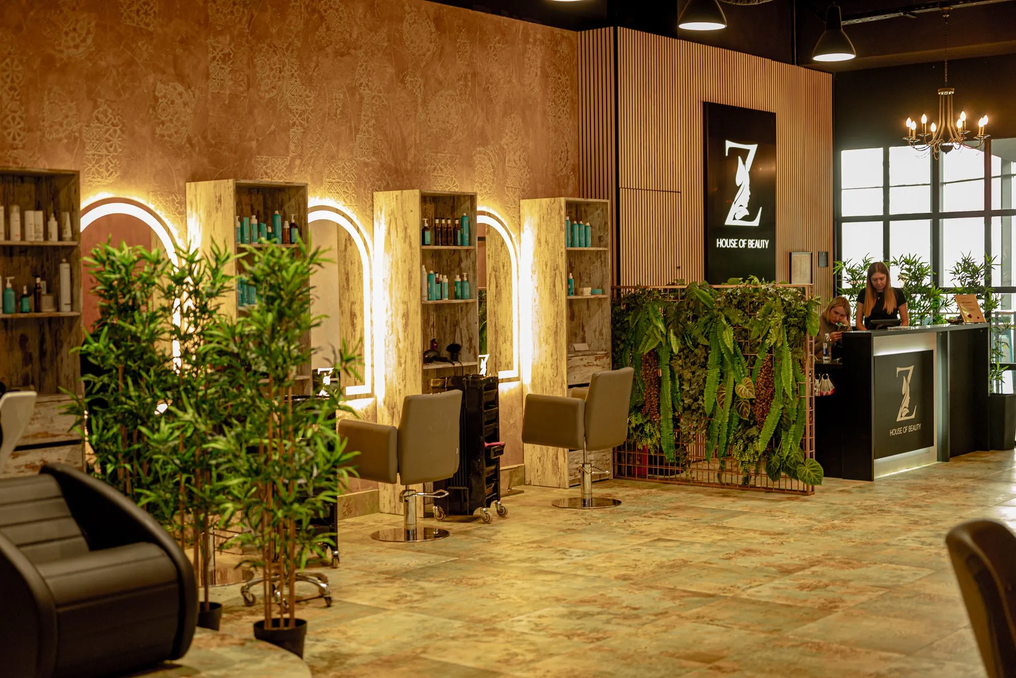 Interijer salona Z House of Beauty: osvijetljena zrcala u obliku luka, zelenilo i recepcija sa znakom Z